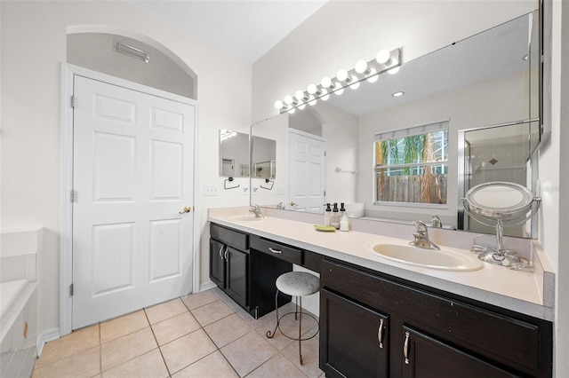 bathroom with a stall shower, tile patterned flooring, a sink, and double vanity
