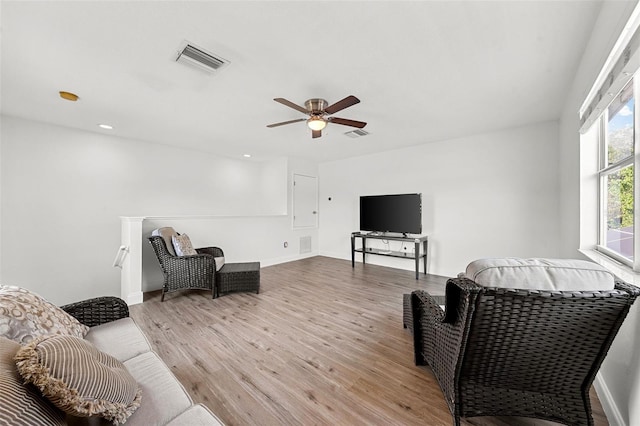 living room with visible vents, a ceiling fan, and light wood finished floors