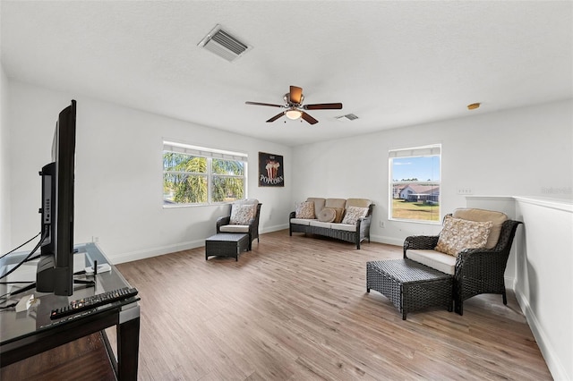 sitting room with baseboards, visible vents, a ceiling fan, and light wood finished floors