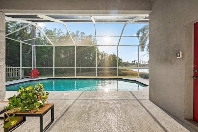 outdoor pool featuring a lanai, a water view, and a patio area