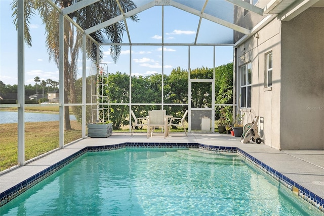 outdoor pool featuring a patio, a water view, and glass enclosure