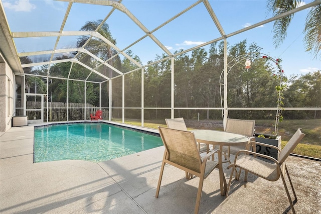 view of pool featuring a fenced in pool, glass enclosure, and a patio area