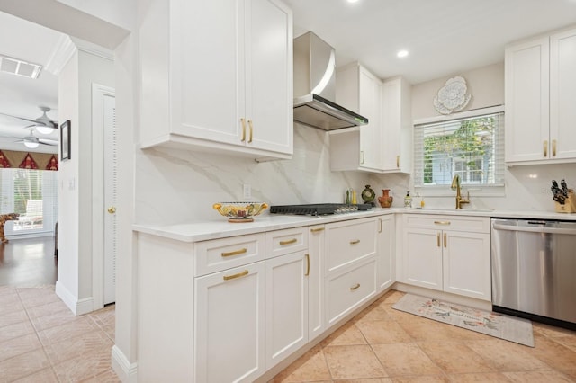 kitchen with a sink, visible vents, stainless steel appliances, light countertops, and wall chimney exhaust hood