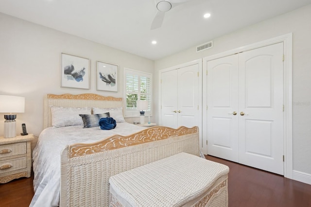 bedroom featuring two closets, recessed lighting, visible vents, and dark wood finished floors