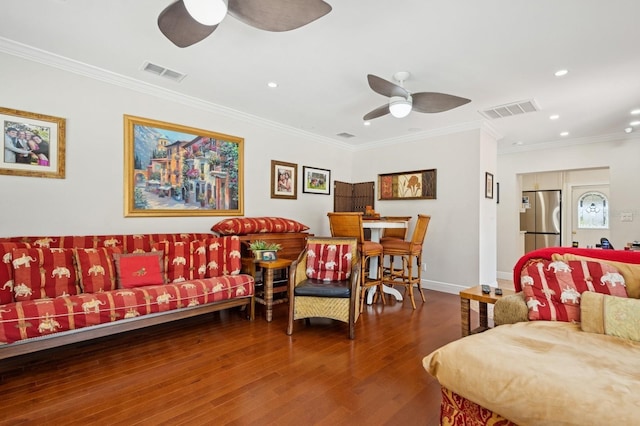 living room with ornamental molding, wood finished floors, ceiling fan, and visible vents