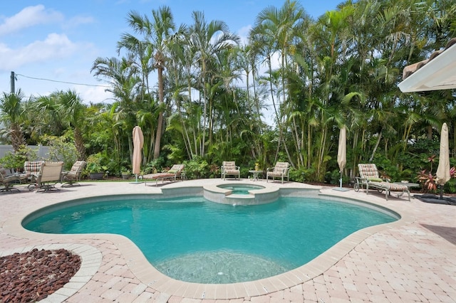 view of pool with a patio area and a pool with connected hot tub