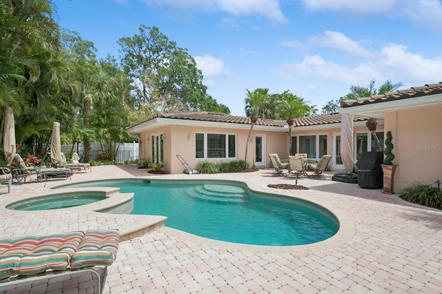 view of swimming pool featuring fence, a patio area, and a pool with connected hot tub
