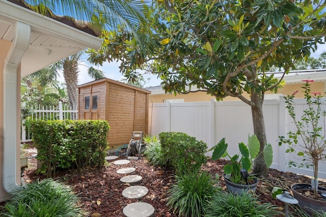 view of yard featuring an outdoor structure, a storage shed, and fence