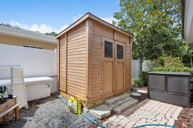 view of shed featuring fence