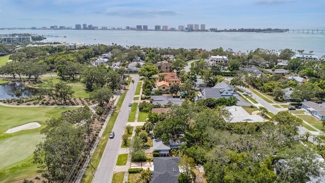 drone / aerial view featuring a residential view, a water view, golf course view, and a city view