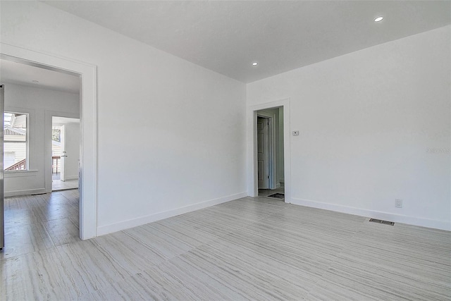unfurnished room featuring recessed lighting, visible vents, light wood-style floors, and baseboards
