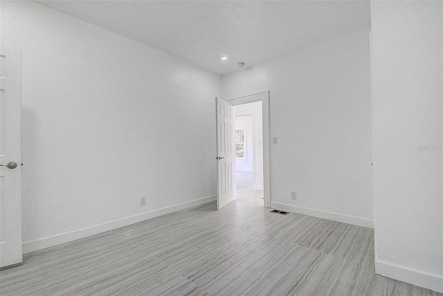 unfurnished room with baseboards, recessed lighting, visible vents, and light wood-style floors