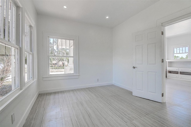 empty room with wood finished floors, recessed lighting, and baseboards