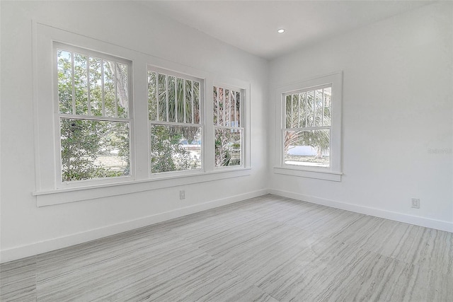 empty room with baseboards, recessed lighting, and wood finished floors