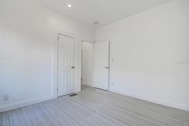 unfurnished room featuring visible vents, recessed lighting, light wood-style flooring, and baseboards