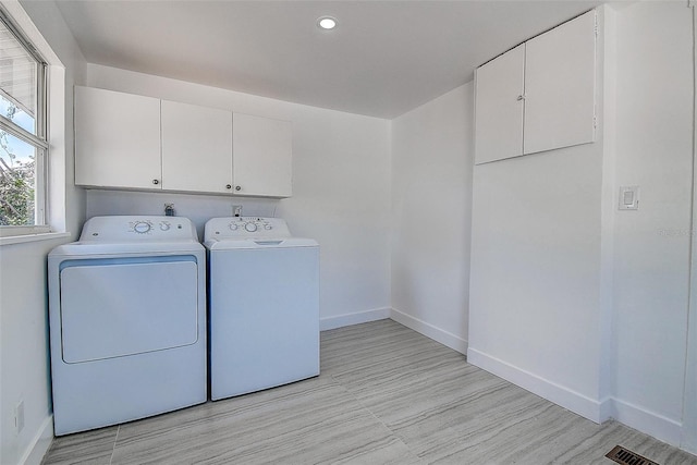 laundry area with baseboards, recessed lighting, cabinet space, and washing machine and dryer