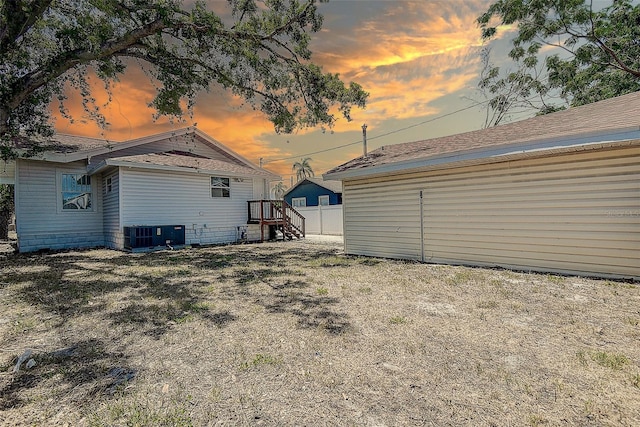 yard at dusk with central AC unit