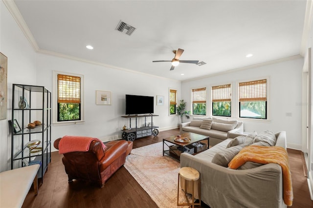 living room with dark wood finished floors, a ceiling fan, baseboards, visible vents, and ornamental molding