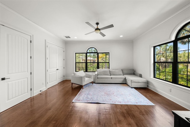 living area with plenty of natural light, ornamental molding, dark wood-style floors, and ceiling fan