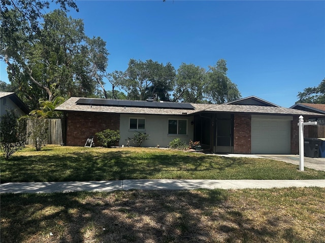 2154 Briarway Dr, Clearwater, FL 33763 - ranch-style house with an attached garage, brick siding, roof mounted solar panels, and driveway