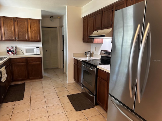 2154 Briarway Dr, Clearwater, FL 33763 - kitchen with appliances with stainless steel finishes, ventilation hood, light countertops, and light tile patterned flooring