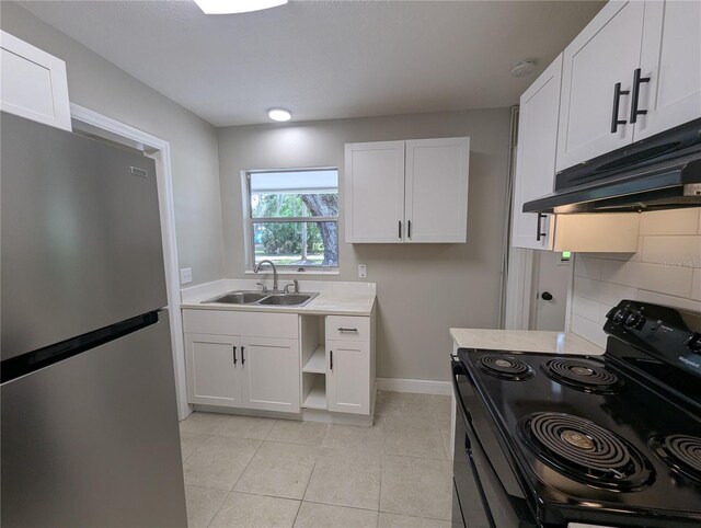 kitchen featuring black range with electric stovetop, a sink, light countertops, freestanding refrigerator, and under cabinet range hood