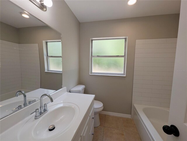 bathroom featuring vanity, baseboards, tile patterned flooring, and toilet
