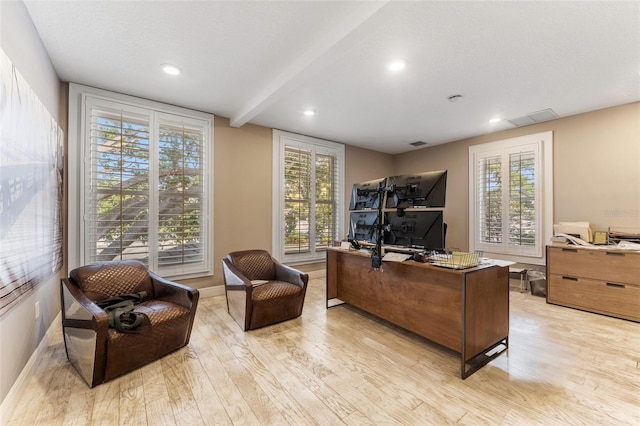 office featuring light wood finished floors, visible vents, and a wealth of natural light