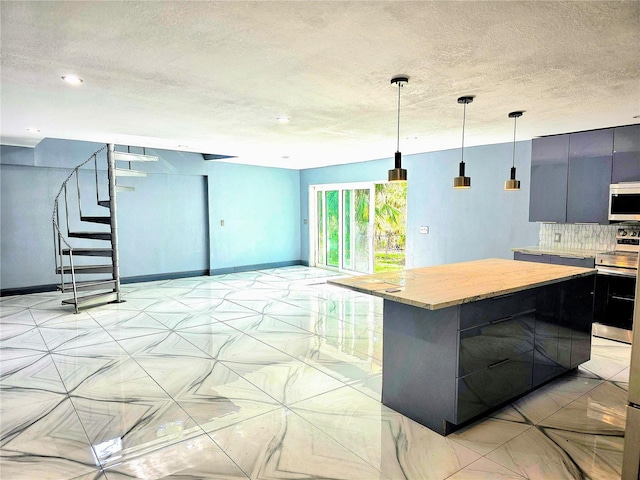 3911 6th Ave W, Palmetto, FL 34221 - kitchen with stainless steel appliances, a textured ceiling, light countertops, modern cabinets, and a kitchen island