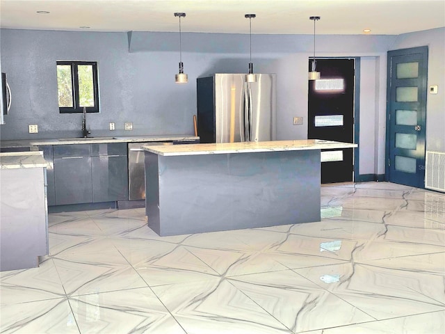 3911 6th Ave W, Palmetto, FL 34221 - kitchen with appliances with stainless steel finishes, a center island, decorative light fixtures, and light stone counters