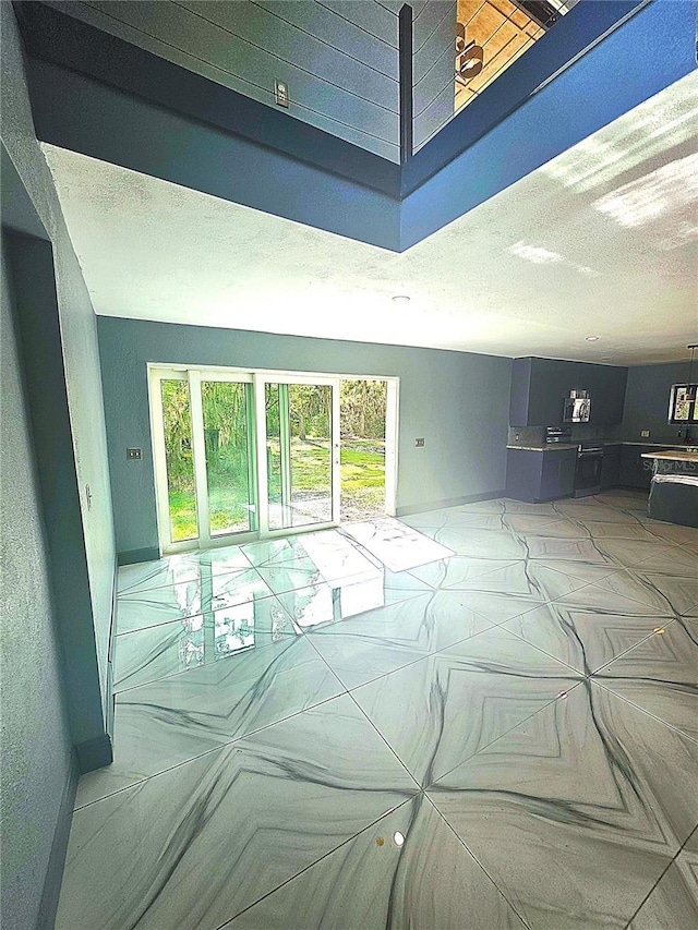 3911 6th Ave W, Palmetto, FL 34221 - living room featuring a textured ceiling and baseboards
