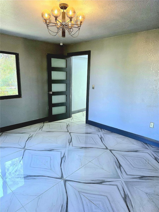 3911 6th Ave W, Palmetto, FL 34221 - unfurnished room with a chandelier, a textured ceiling, and marble look tiles