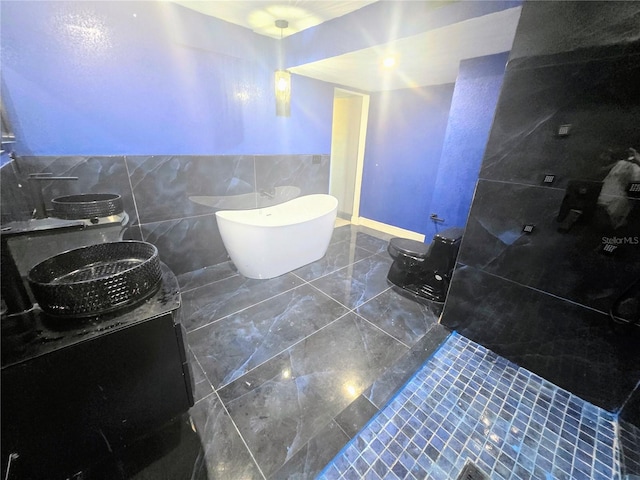 3911 6th Ave W, Palmetto, FL 34221 - bathroom featuring tile walls, vanity, a soaking tub, and marble finish flooring