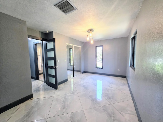 3911 6th Ave W, Palmetto, FL 34221 - unfurnished room featuring a textured wall, light marble finish floors, and a textured ceiling