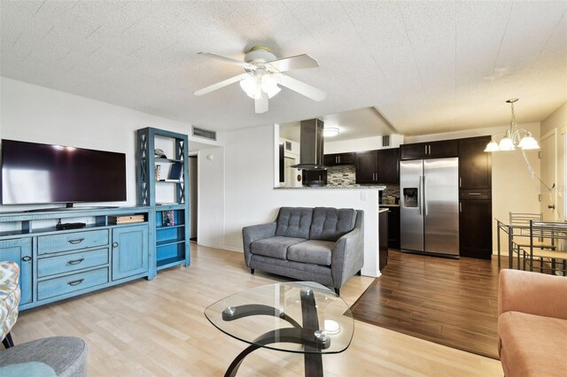1235 S Highland Ave Unit 2-207, Clearwater, FL 33756 - living room featuring light wood-type flooring, a ceiling fan, and a chandelier