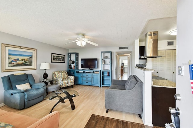 1235 S Highland Ave Unit 2-207, Clearwater, FL 33756 - living area featuring light wood-type flooring, ceiling fan, and a textured ceiling