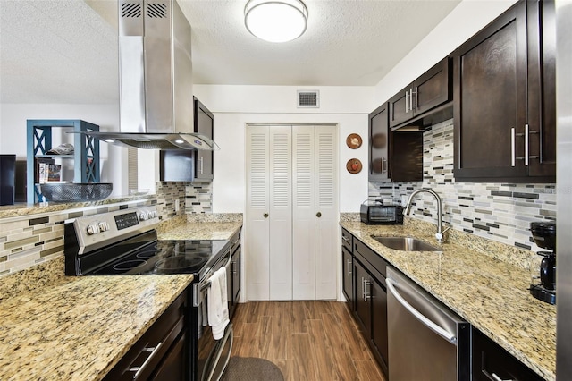1235 S Highland Ave Unit 2-207, Clearwater, FL 33756 - kitchen with appliances with stainless steel finishes, a sink, wall chimney range hood, backsplash, and a textured ceiling
