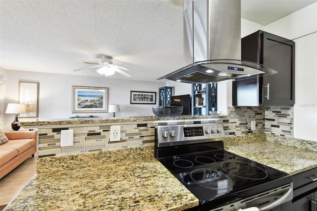 1235 S Highland Ave Unit 2-207, Clearwater, FL 33756 - kitchen with electric range, wall chimney range hood, backsplash, a ceiling fan, and light stone countertops