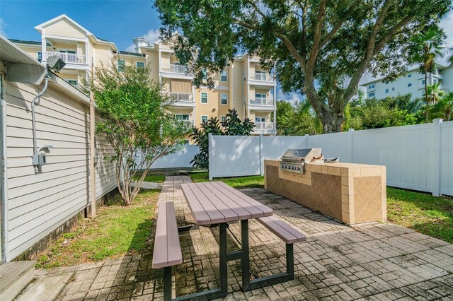 1235 S Highland Ave Unit 2-207, Clearwater, FL 33756 - view of patio featuring an outdoor kitchen, a fenced backyard, area for grilling, and outdoor dining area