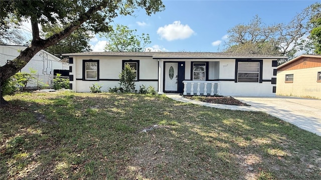 7017 Baywood Dr, Tampa, FL 33637 - ranch-style home with a front lawn, stucco siding, covered porch, and fence