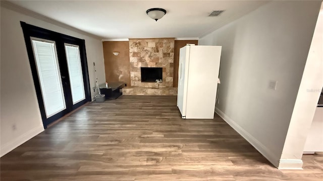 7017 Baywood Dr, Tampa, FL 33637 - unfurnished living room featuring wood finished floors, visible vents, a fireplace, crown molding, and baseboards