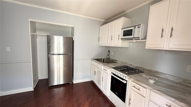 7017 Baywood Dr, Tampa, FL 33637 - kitchen featuring white appliances, a sink, white cabinetry, crown molding, and dark wood-style floors