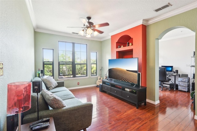 living room with arched walkways, ceiling fan, wood finished floors, and visible vents