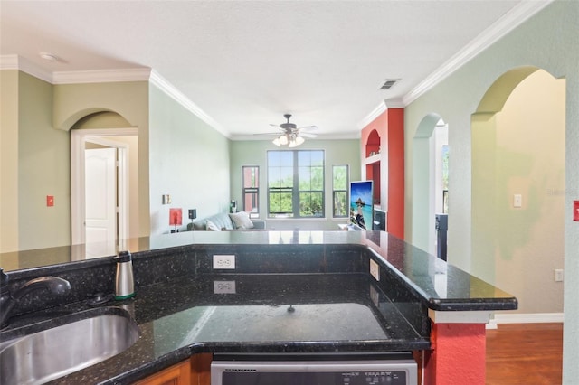 kitchen with visible vents, crown molding, wood finished floors, a sink, and open floor plan