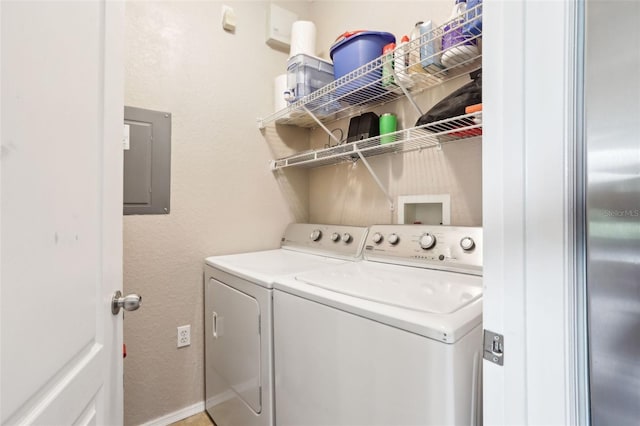 washroom with laundry area, a textured wall, electric panel, and washing machine and clothes dryer