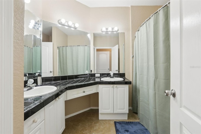 bathroom with double vanity, tile patterned floors, and a sink