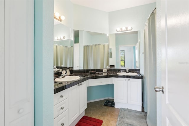 full bath with double vanity, a sink, and tile patterned flooring