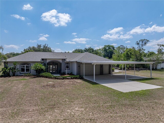 view of front of property with stucco siding, a shingled roof, a carport, driveway, and a front lawn
