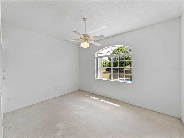 unfurnished room featuring a textured ceiling, ceiling fan, and carpet