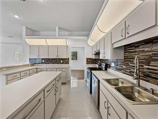kitchen with a sink, decorative backsplash, stainless steel appliances, under cabinet range hood, and light countertops
